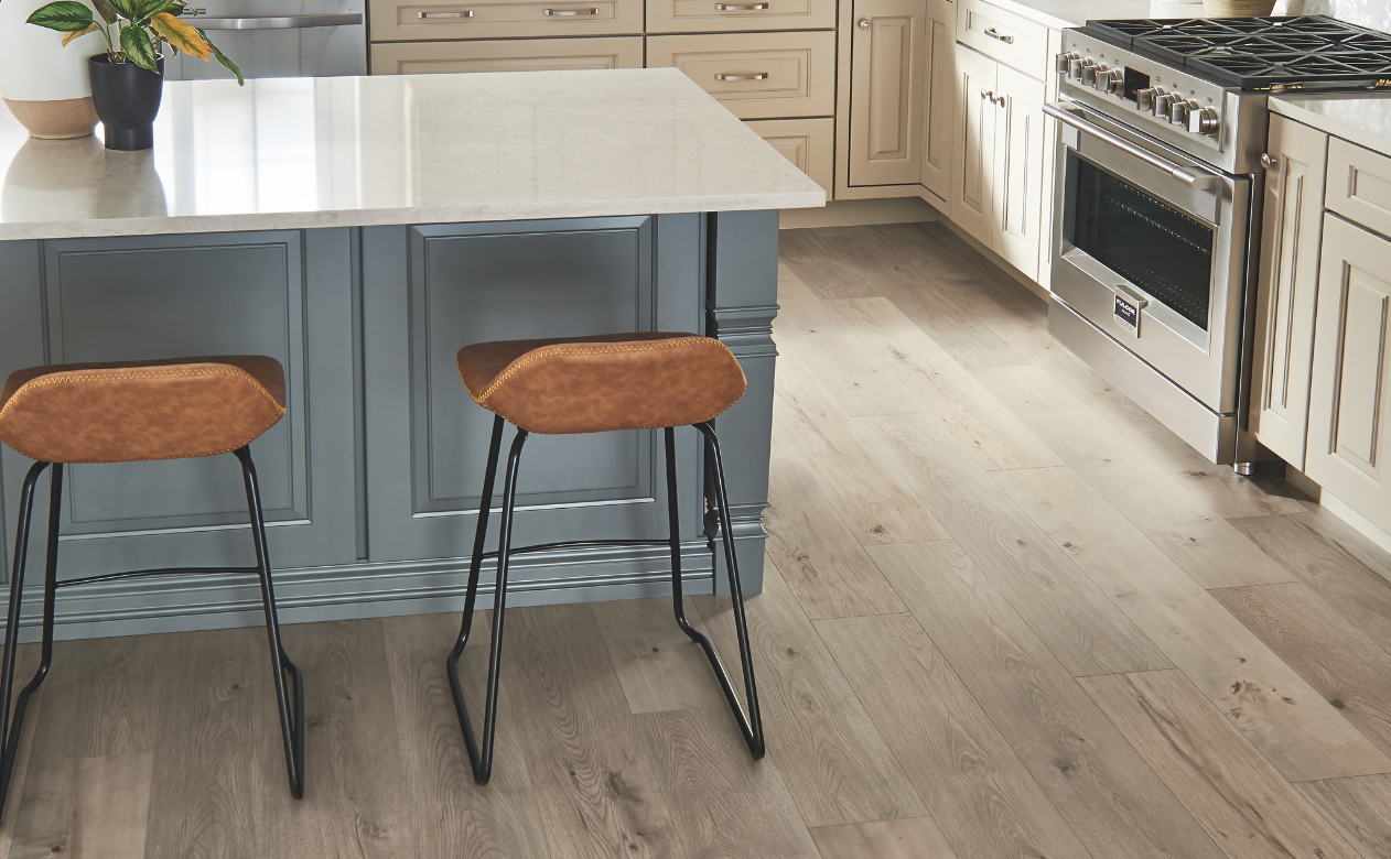 Kitchen with laminate flooring, a kitchen island and two barstools