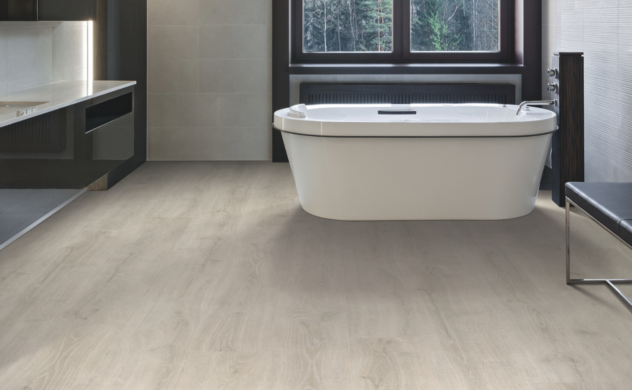 Laminate flooring in a bathroom with light laminate flooring and a bathtub